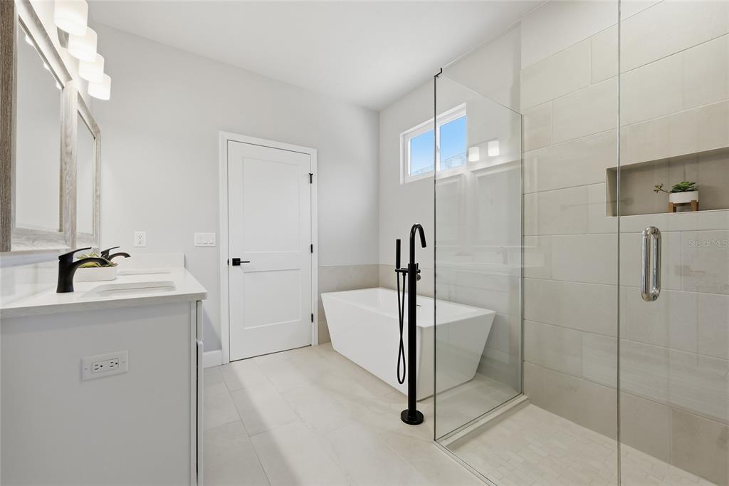 9533 Southwest 66th Lane Gainesville, FL 32608 - Photo 18 of 32 a bathroom with a granite countertop sink a mirror and shower