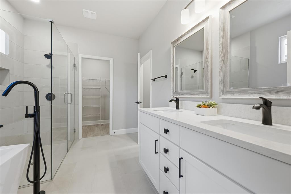 9533 Southwest 66th Lane Gainesville, FL 32608 - Photo 20 of 32 a bathroom with a double vanity sink a mirror and a shower