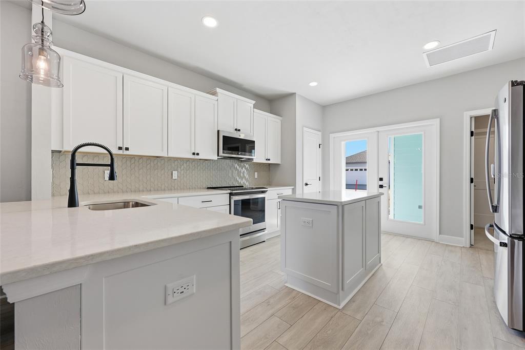 9533 Southwest 66th Lane Gainesville, FL 32608 - Photo 23 of 32 a kitchen with a refrigerator stove and white cabinets