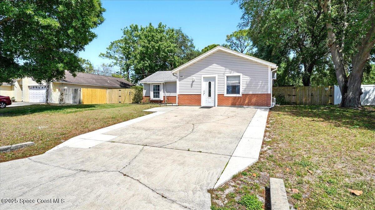 a front view of a house with a yard and trees