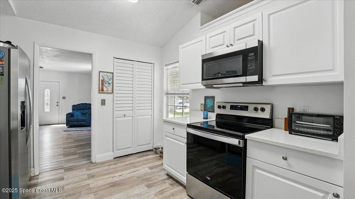 6615 Dock Avenue Cocoa, FL 32927 - Photo 11 of 38 a kitchen with white cabinets and black appliances