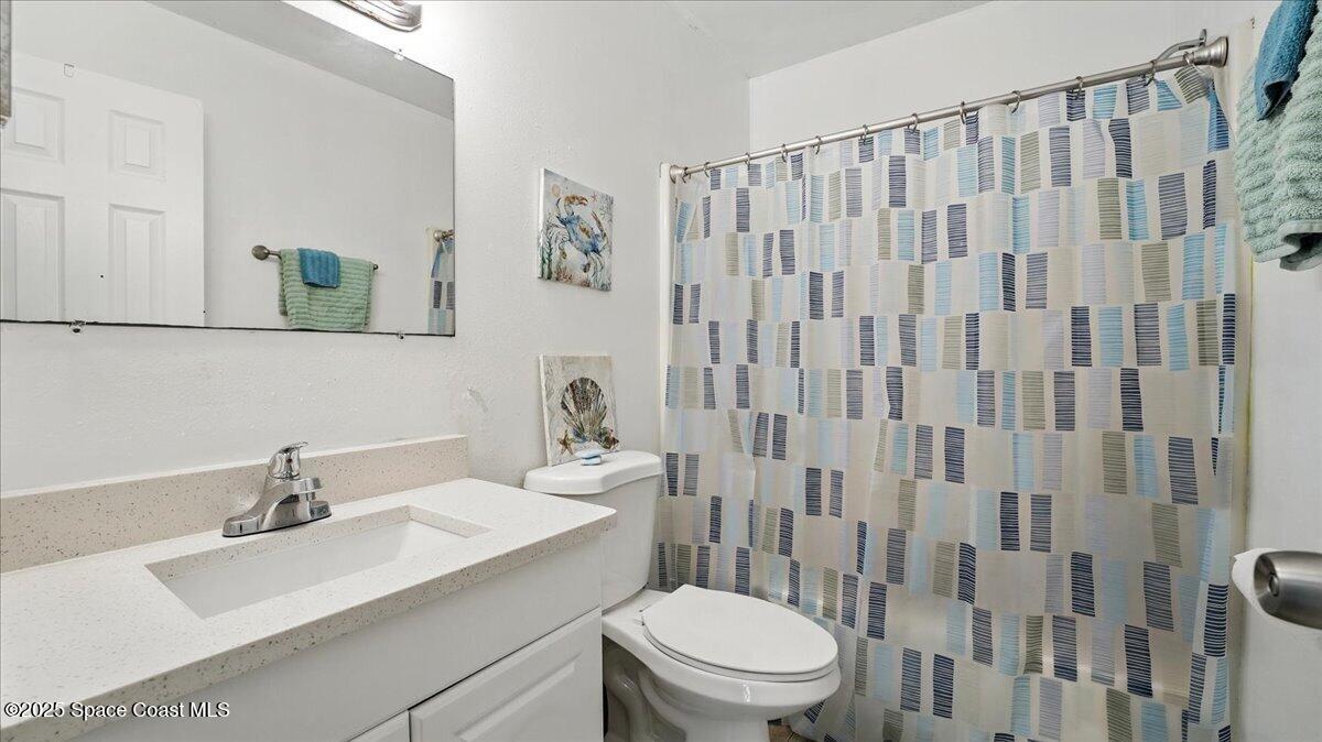 6615 Dock Avenue Cocoa, FL 32927 - Photo 19 of 38 a bathroom with a sink a toilet and shower curtain