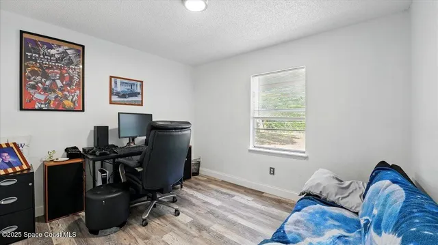 a view of a workspace with furniture and a window