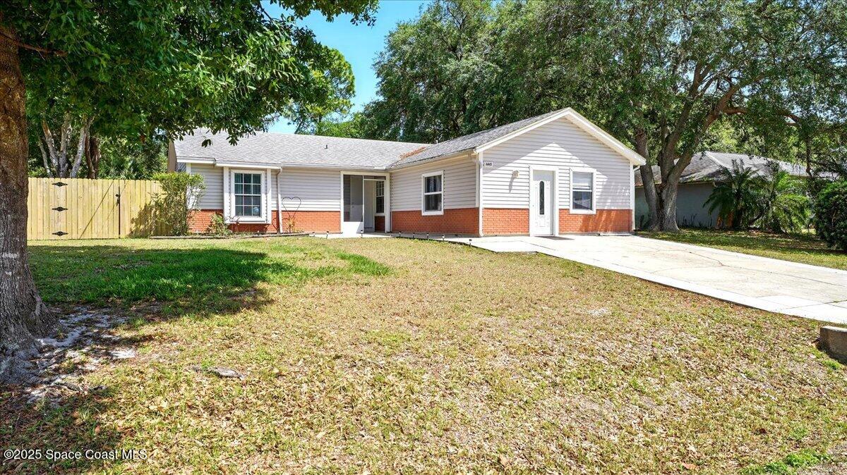 6615 Dock Avenue Cocoa, FL 32927 - Photo 2 of 38 a front view of a house with a yard and garage