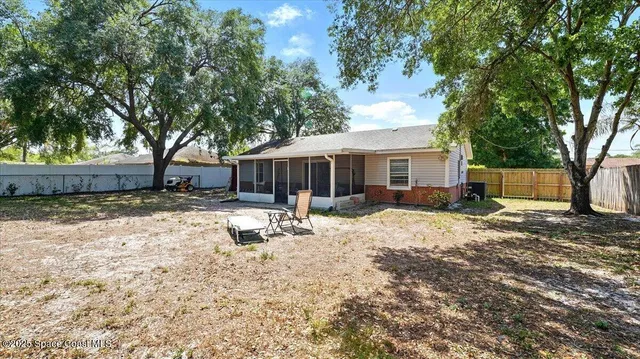 a backyard of a house with table and chairs