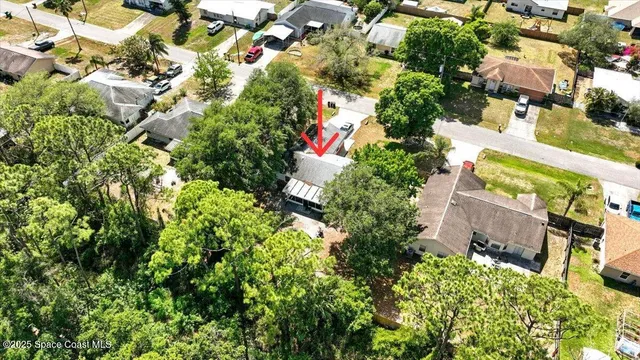 an aerial view of residential house with outdoor space and trees all around