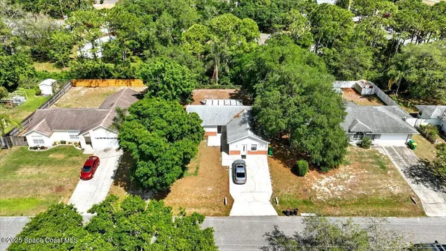 an aerial view of a house with a yard and trees