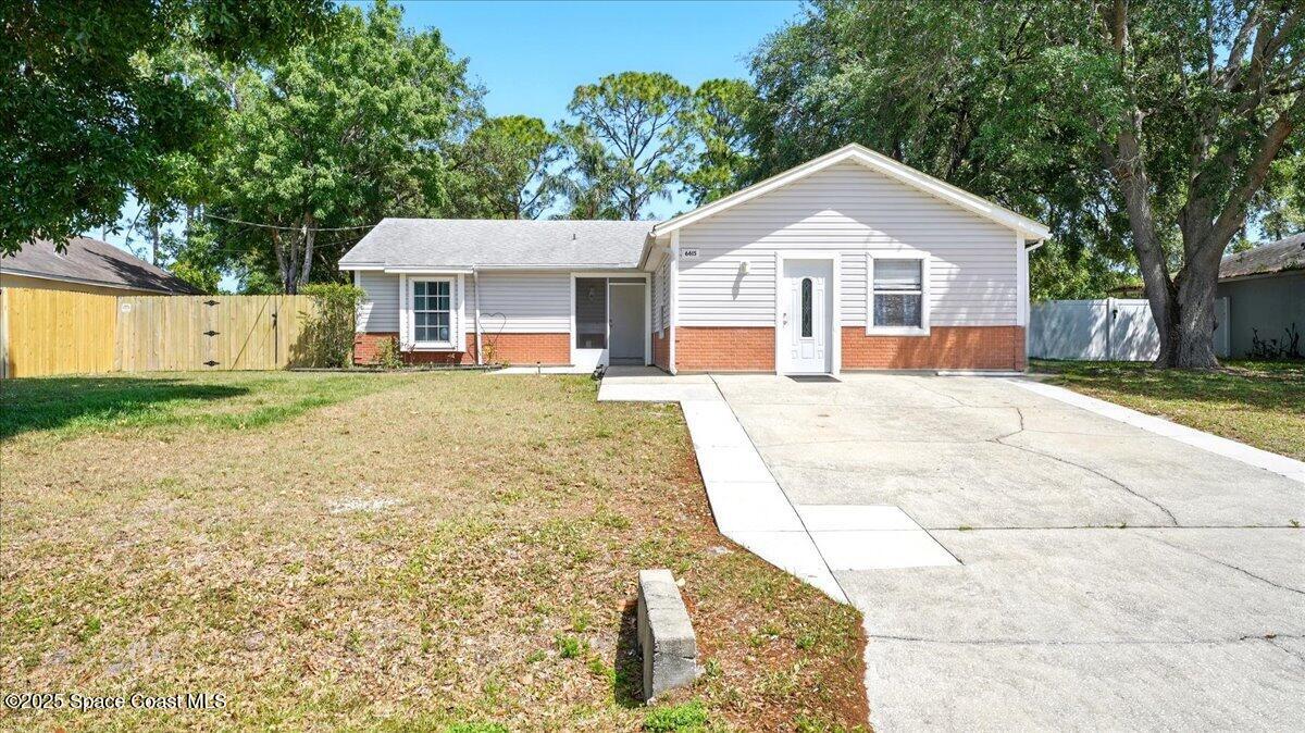 6615 Dock Avenue Cocoa, FL 32927 - Photo 3 of 38 a front view of a house with a yard and garage