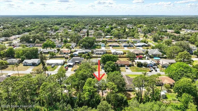 an aerial view of residential houses with outdoor space and trees
