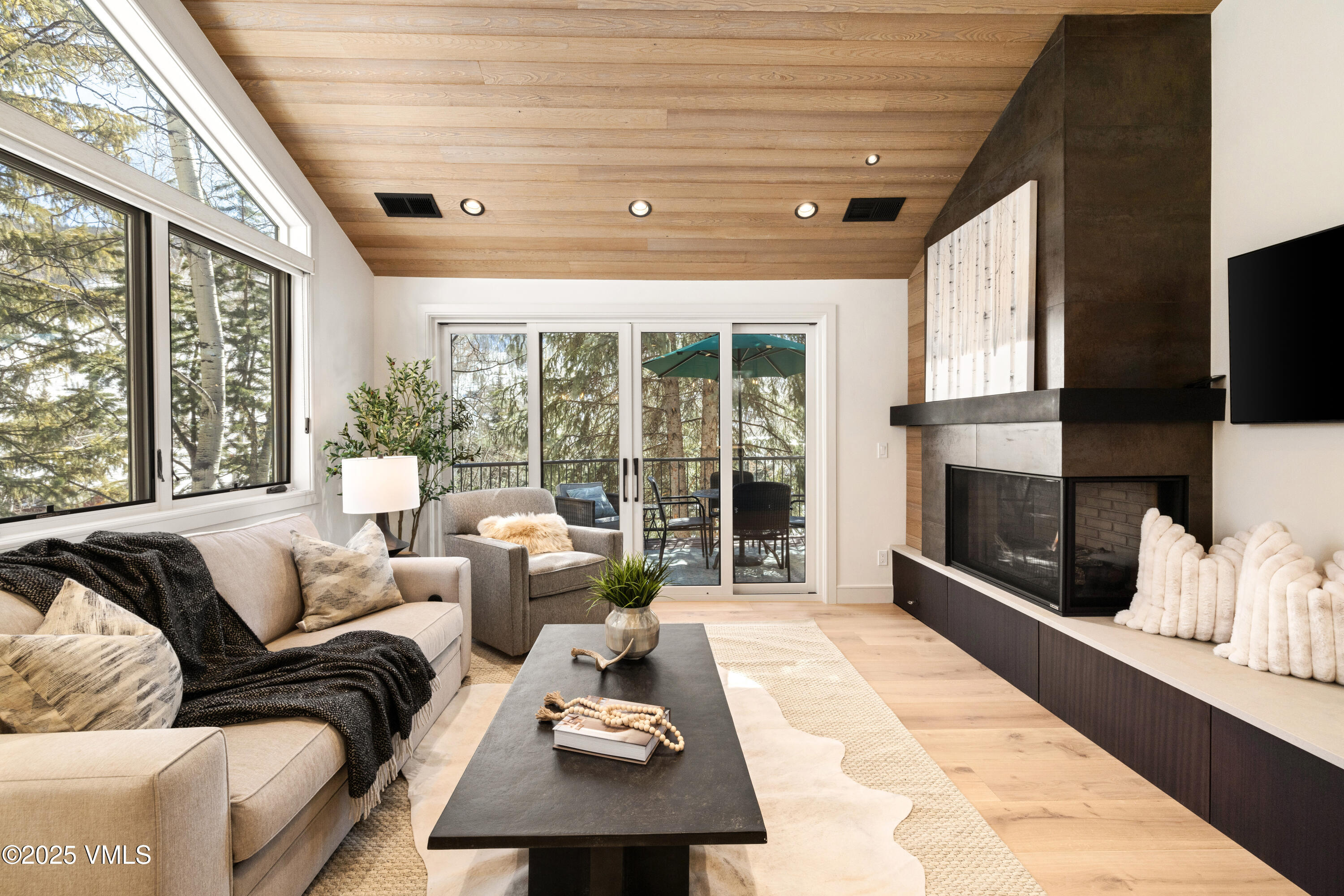 1881 Lions Ridge Loop, Unit 2 Vail, CO 81657 - Photo 3 of 41 a living room with furniture a flat screen tv and a floor to ceiling window