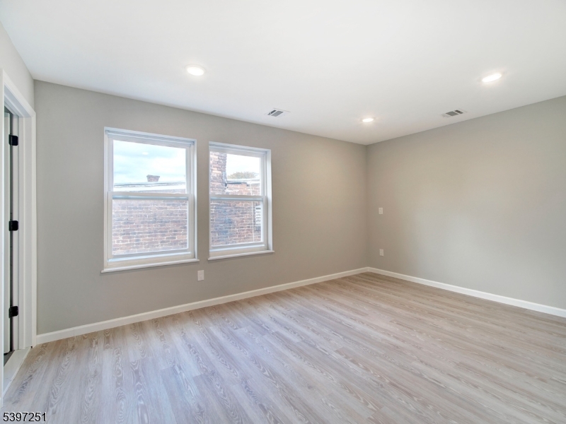 32 North 14th Street, Unit 2 Newark, NJ 07107 - Photo 13 of 14 an empty room with wooden floor and windows