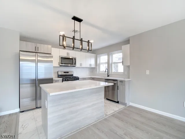 a kitchen with a refrigerator a stove top oven a sink and dishwasher