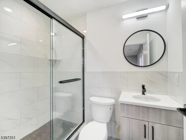 a bathroom with a shower sink mirror and toilet