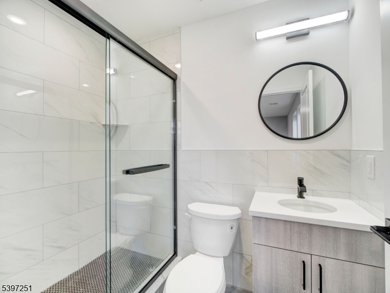 32 North 14th Street, Unit 2 Newark, NJ 07107 - Photo 6 of 14 a bathroom with a shower sink mirror and toilet