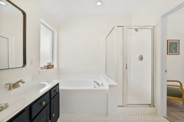 a bathroom with a tub a sink and a mirror