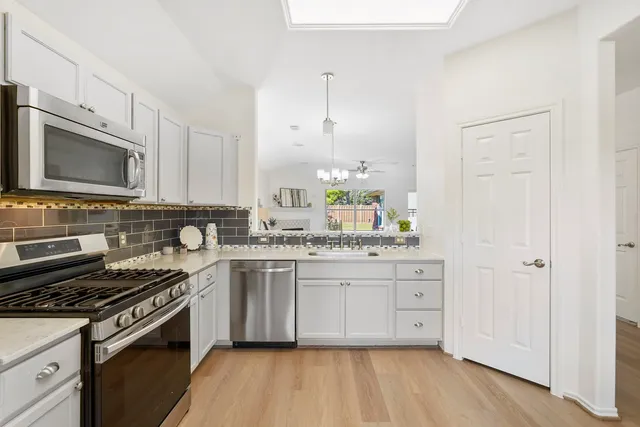 a kitchen with stainless steel appliances granite countertop a stove and a sink