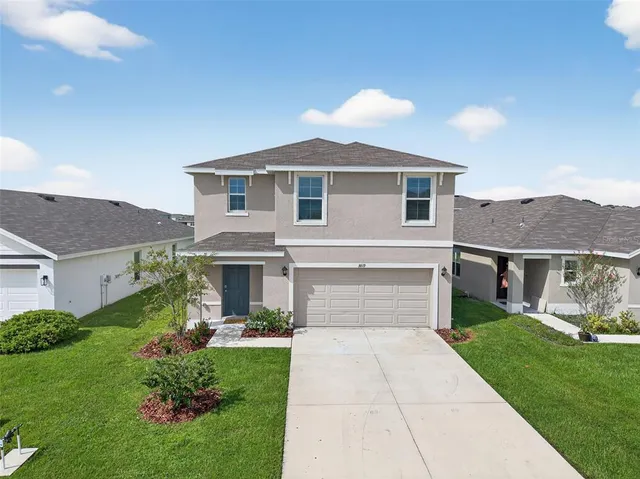 a front view of a house with a yard and garage