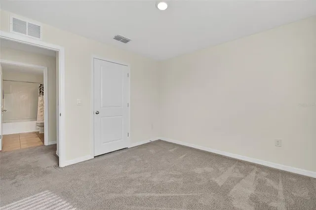 a view of a white house with a big yard and potted plants