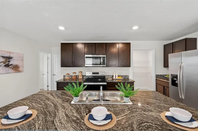 a kitchen with sink refrigerator and dining table
