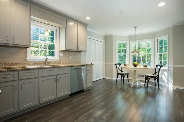 a kitchen with a table chairs sink and cabinets