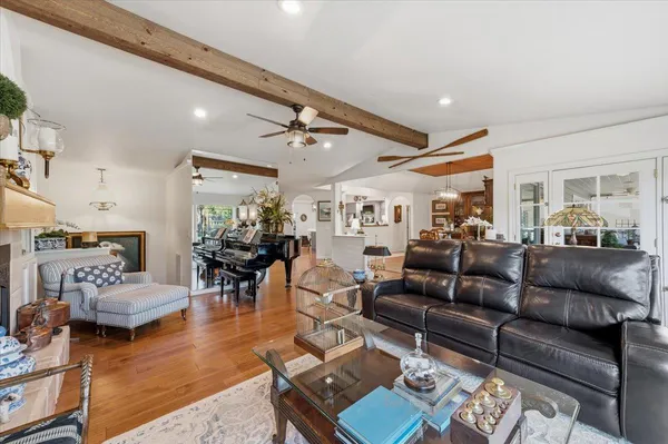 a dining room with wooden floor a chandelier a glass table and chairs