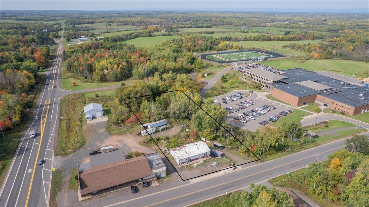 Aerial view of property and surrounding area featuring property parcel outlined