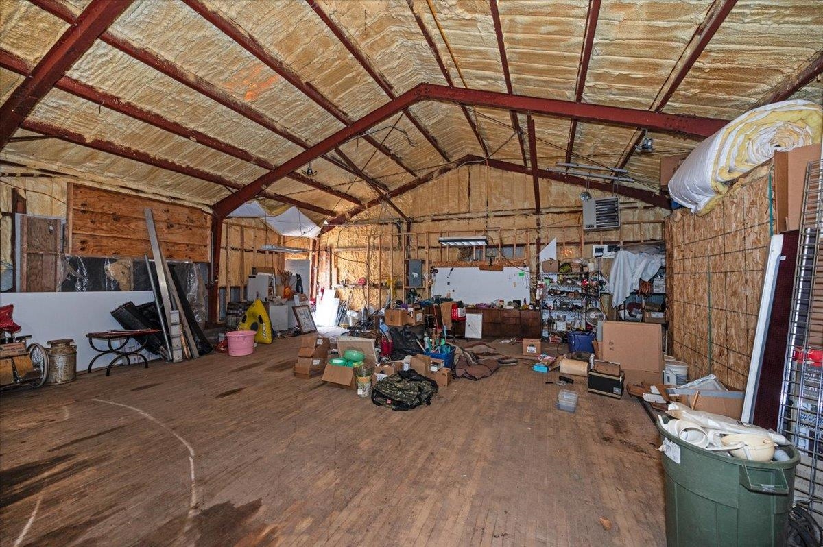 4781 County Rd F Maple, WI 54854 - Photo 13 of 18 Misc room featuring a heating unit, high vaulted ceiling, a garage, and hardwood / wood-style flooring