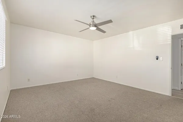 an empty room with a ceiling fan and a window