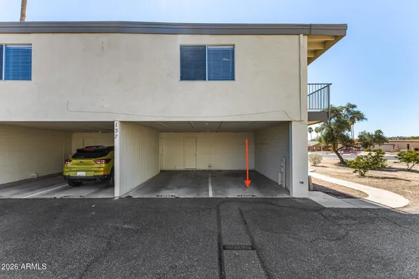 a view of a house with a parking space and a car parked in it