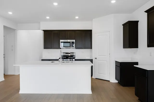 a kitchen with kitchen island a sink stainless steel appliances and cabinets