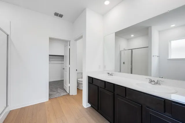 a spacious bathroom with a double vanity sink mirror and shower