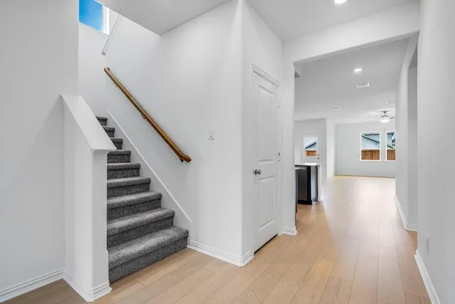 a view of a hallway with wooden floor and entryway