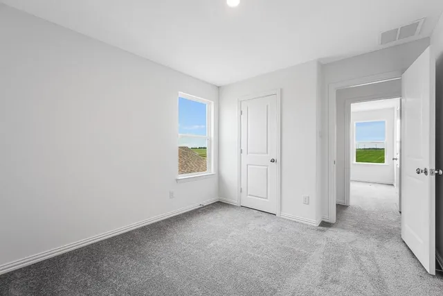 an empty room with windows and closet