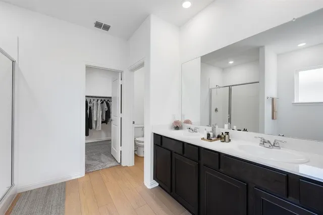 a en suite bathroom with a double vanity sink mirror and toilet