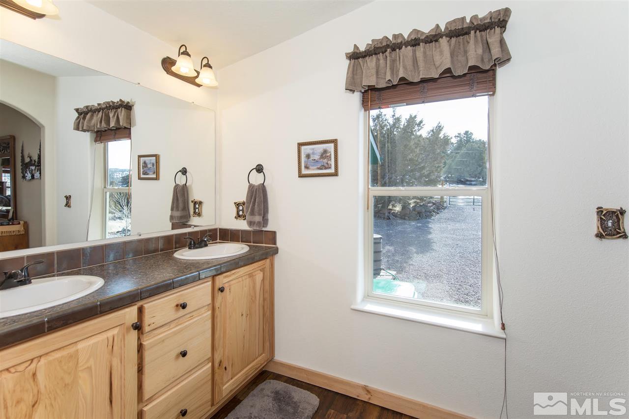 3230 Cartwright Road Reno, NV 89521 - Photo 21 of 25 a bathroom with a granite countertop sink mirror and a window