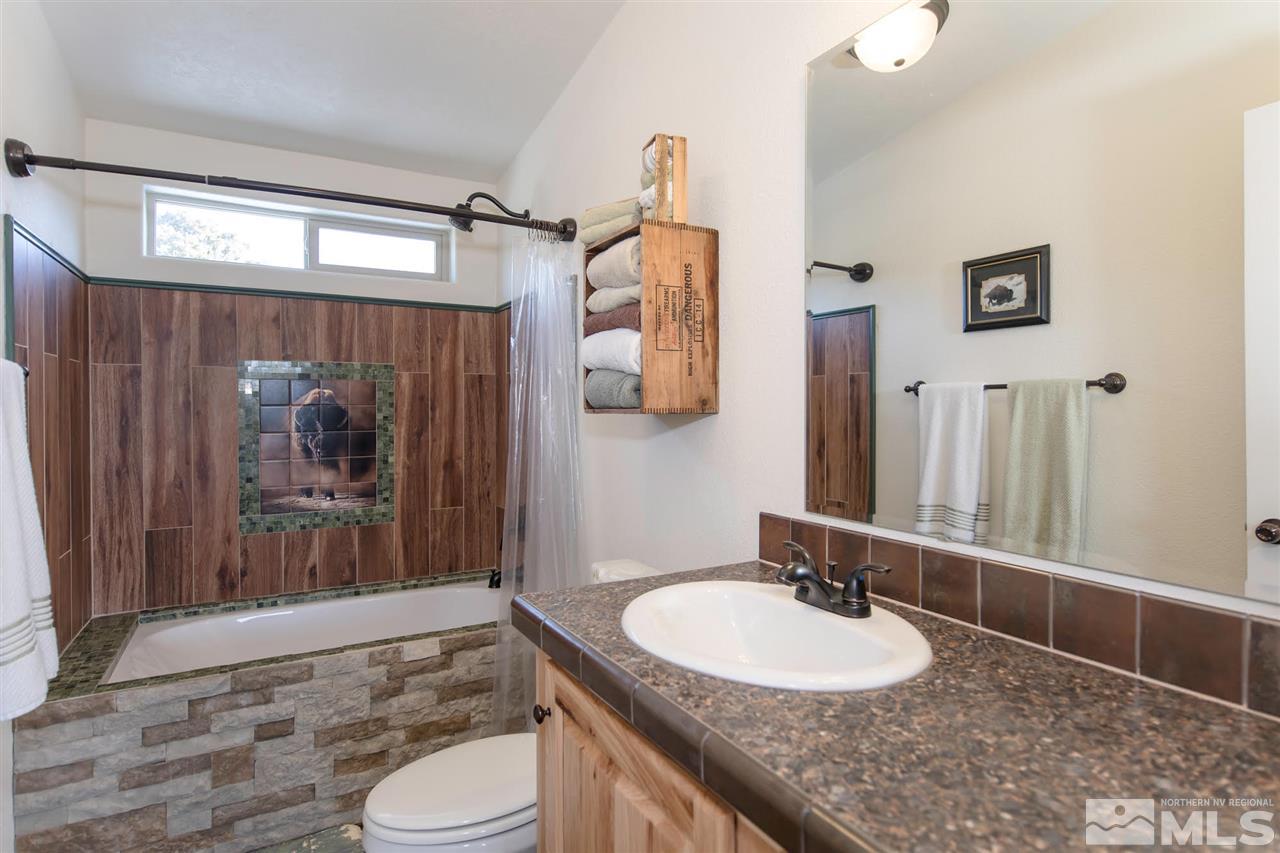 3230 Cartwright Road Reno, NV 89521 - Photo 23 of 25 a bathroom with a granite countertop sink mirror vanity and toilet