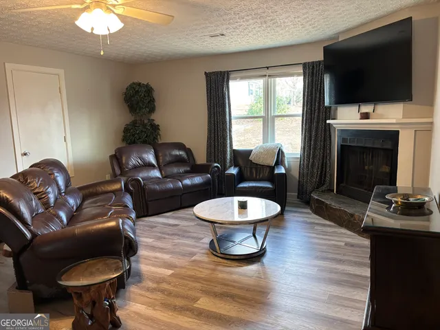a living room with furniture a flat screen tv and a fireplace