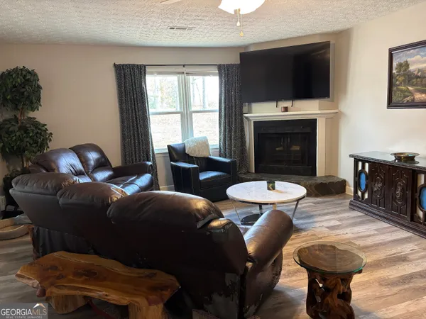 a living room with furniture a flat screen tv and a fireplace