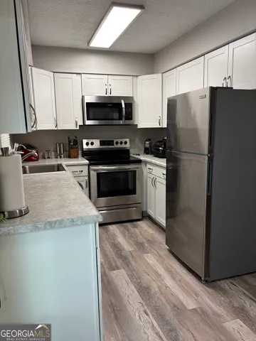 a kitchen with granite countertop a refrigerator stove and microwave