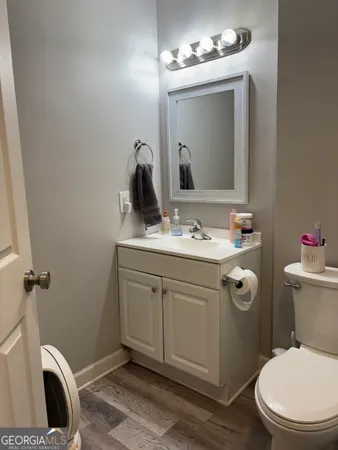 a bathroom with a sink vanity granite toilet and a mirror