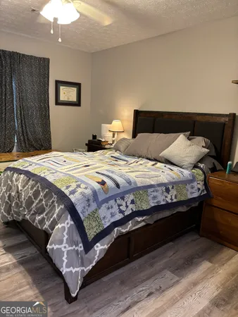 a bedroom with bed and wooden floor