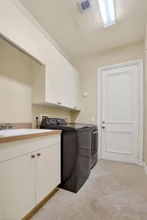 a bedroom with a bed and a lamp on dresser