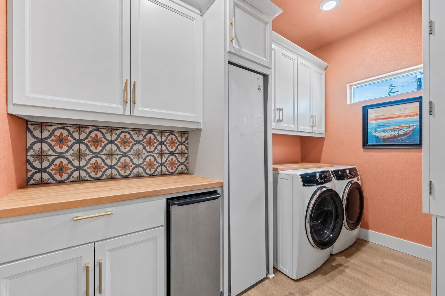 29 Rabbit Drive Port O'Connor, TX 77982 - Photo 7 of 21 Virtually Cleaned: Combining personality with efficiency, this laundry space offers front-load washer and dryer units beneath upper cabinet storage.