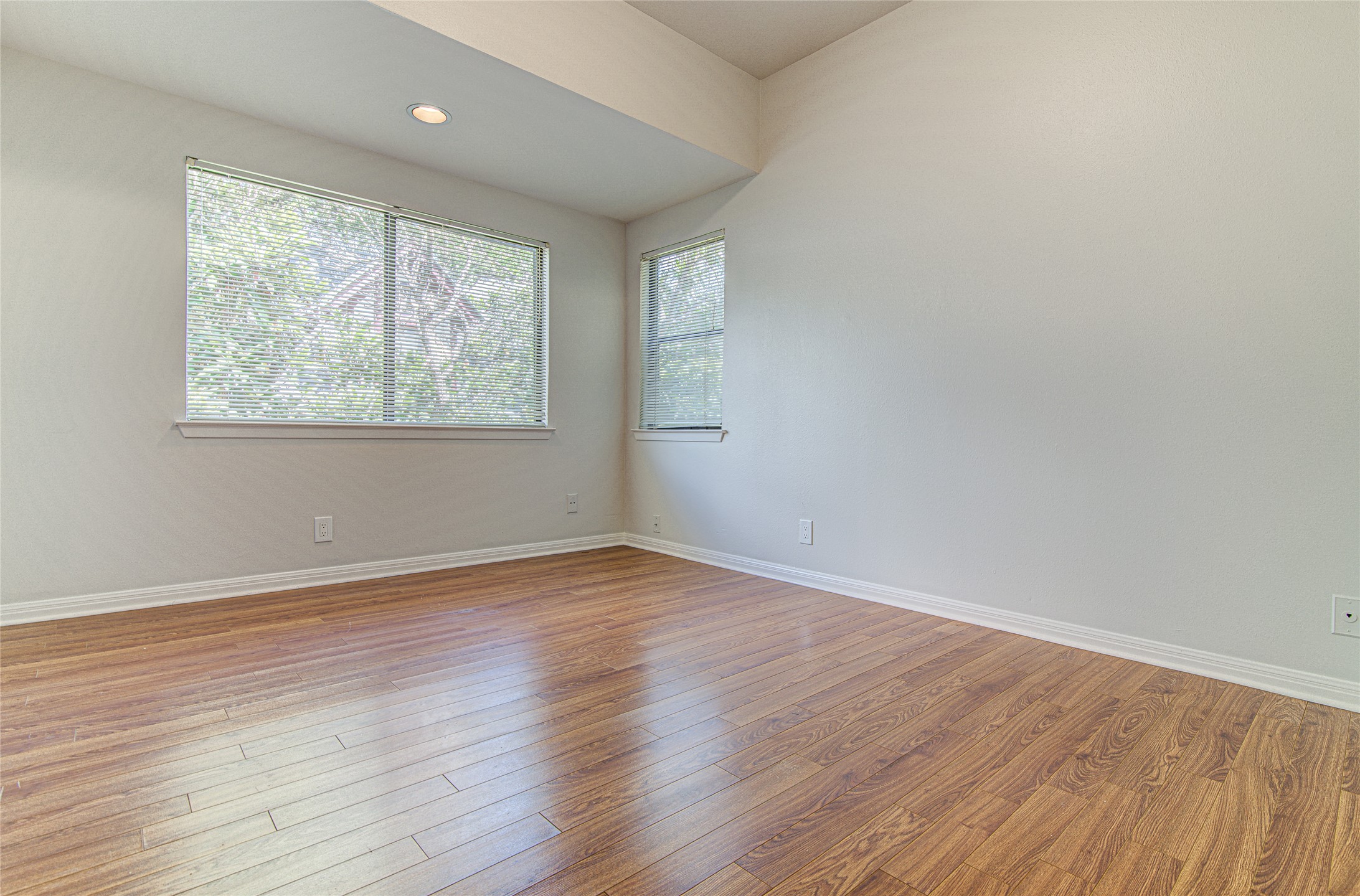 311 West Mary Street Austin, TX 78704 - Photo 8 of 35 Well-lit room featuring rich hardwood flooring and dual windows offering green outdoor views.