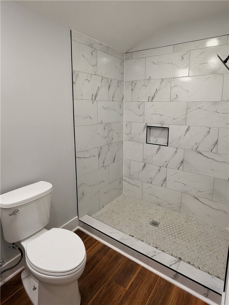 115 Hunter Street Anderson, SC 29625 - Photo 13 of 21 This sleek bathroom features a modern shower with elegant tile work and rich wood flooring.