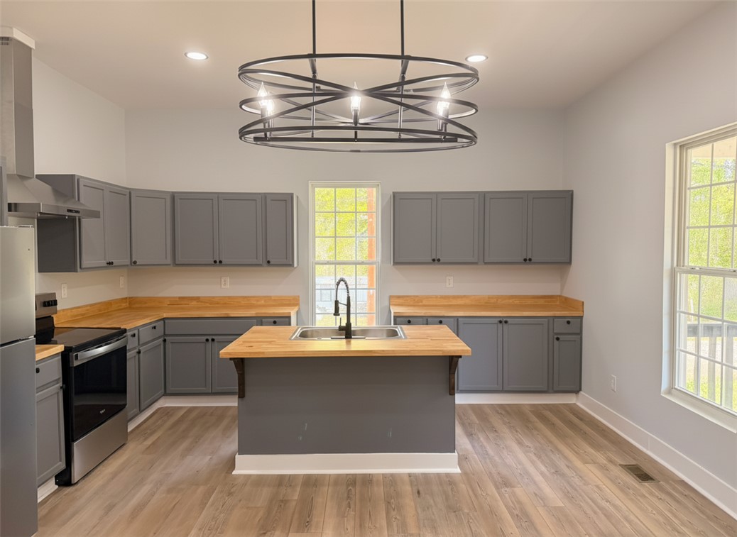 115 Hunter Street Anderson, SC 29625 - Photo 10 of 21 This modern kitchen features a spacious island and sleek cabinetry, ideal for culinary endeavors.