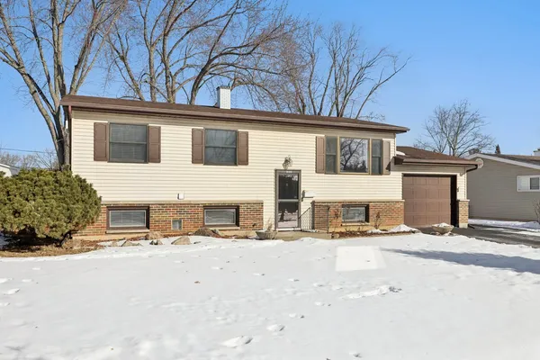 front view of a house with a snow on the road