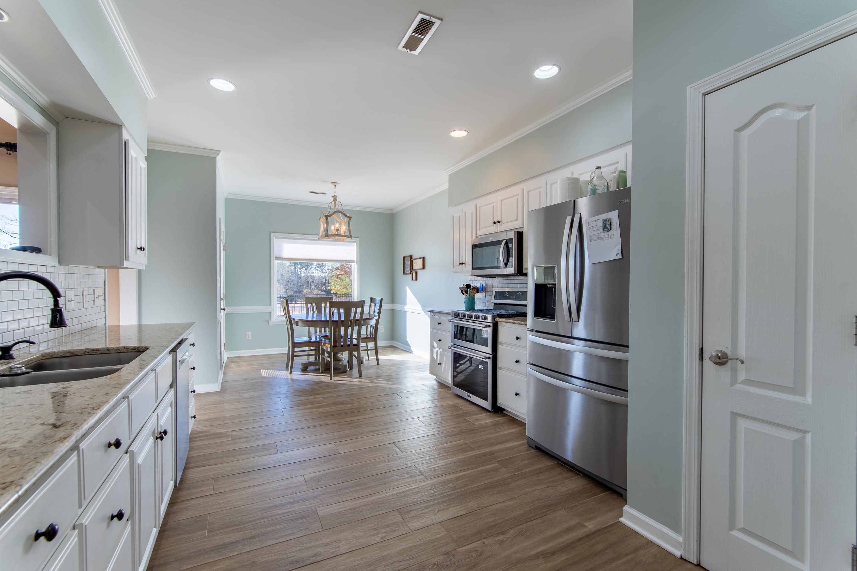 4 Rabbit Cove Corinth, MS 38834 - Photo 9 of 28 a kitchen with stainless steel appliances granite countertop a refrigerator a stove oven a sink dishwasher and white cabinets with wooden floor