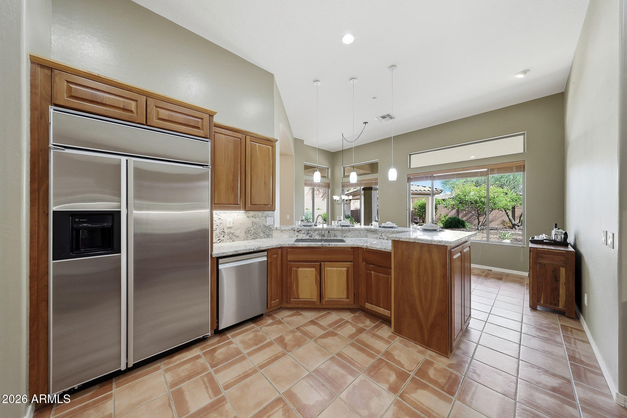 2129 West Legends Way Anthem, AZ 85086 - Photo 15 of 57 a kitchen with kitchen island granite countertop a refrigerator stove and sink