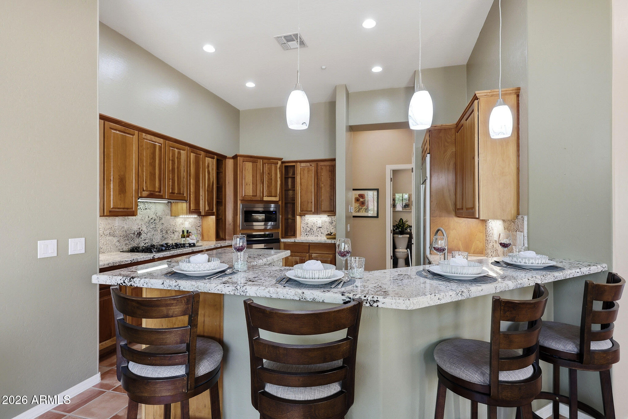 2129 West Legends Way Anthem, AZ 85086 - Photo 20 of 57 a kitchen with kitchen island granite countertop a sink and a stove